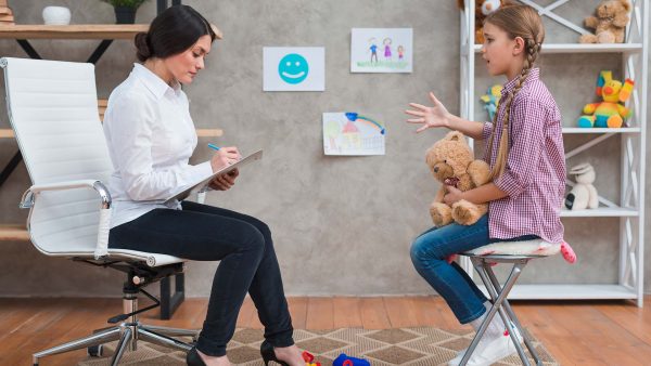 female-psychologist-taking-notes-during-therapy-session